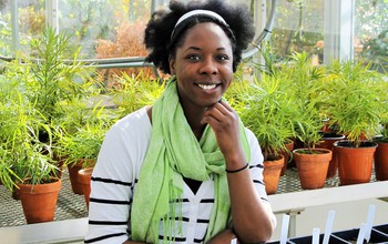 Lekeah A. Durden in a greenhouse with plants
